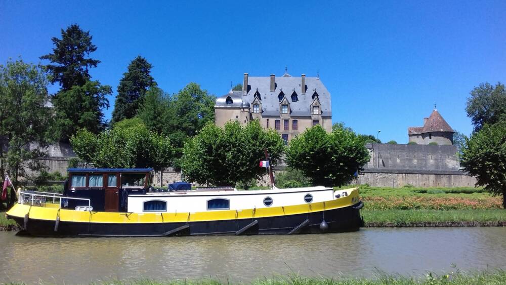 Bateau de plaisance sur le Canal du Nivernais devant le Château de Châtillon-en-Bazois